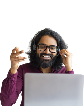 A smiling Indian woman with headphones in front of a computer