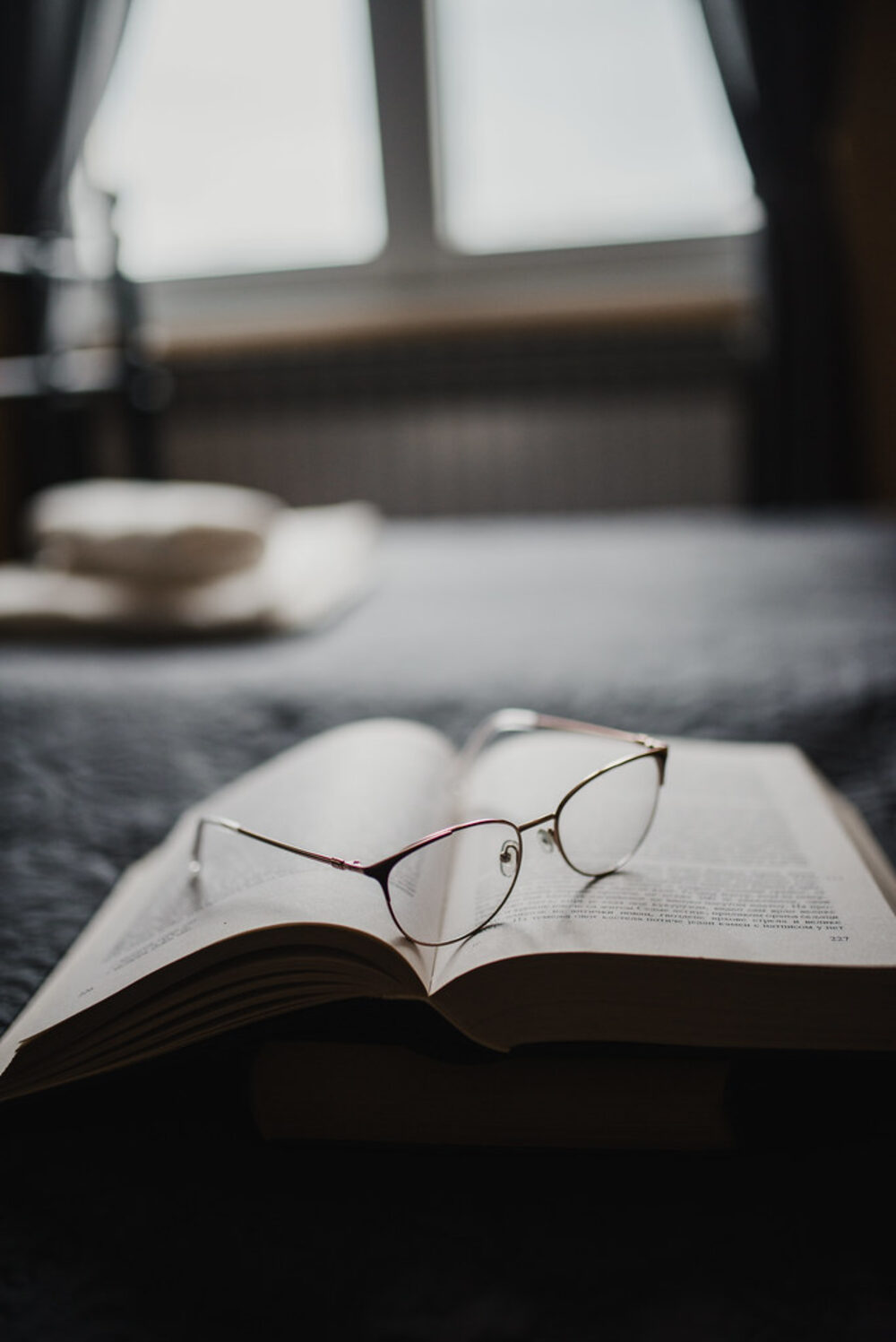 A reader holding a document close, glasses in hand.